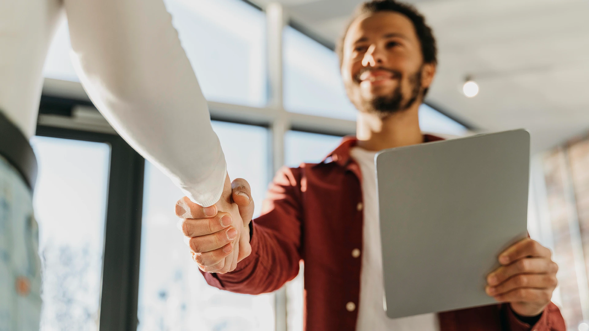 Dos personas haciendo negocios dándose la mano.